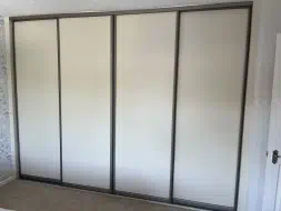 4 Plain wood panel mussel doors with a champagne frame, installed in Ingleby Barwick